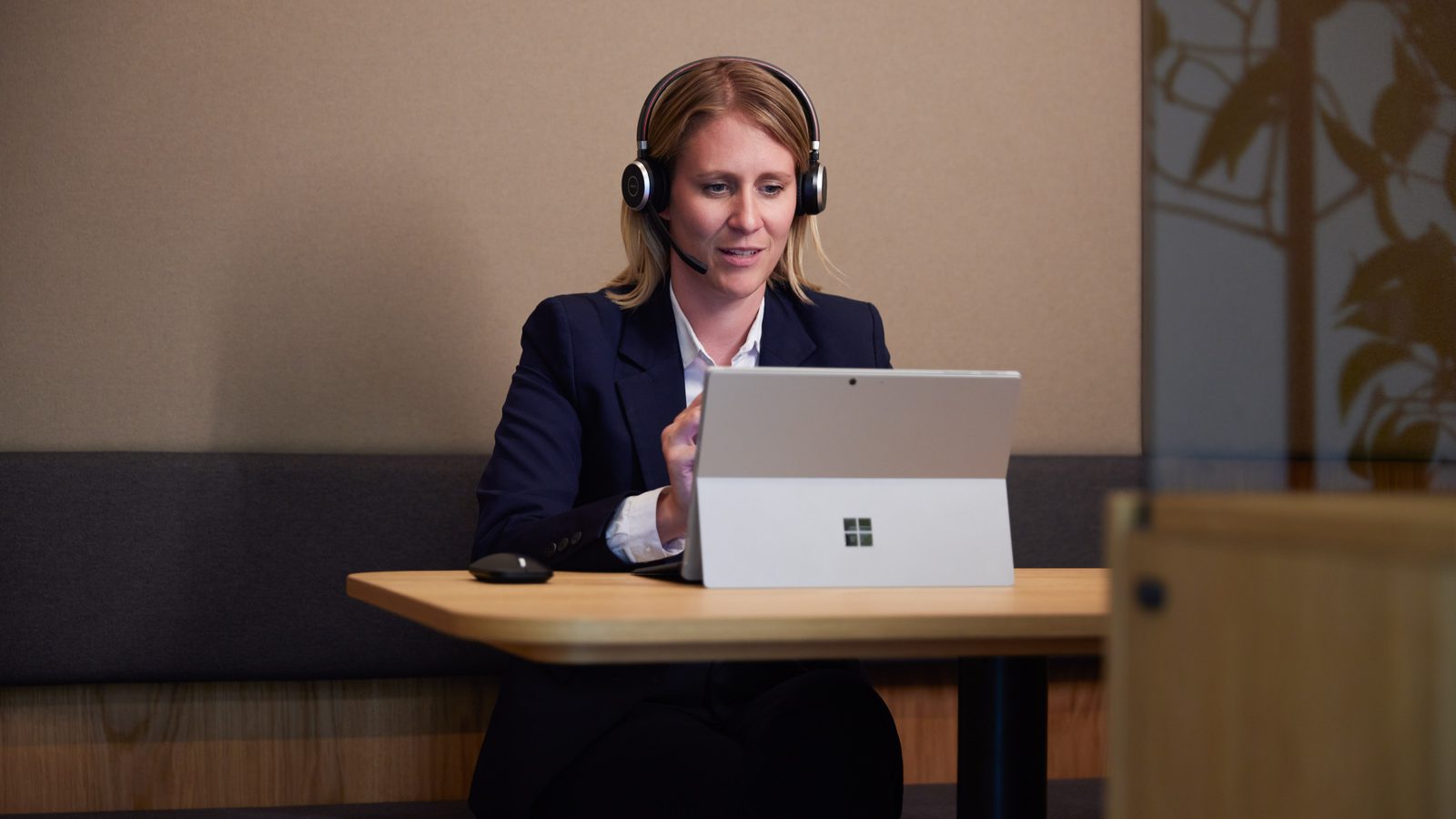 Eine ReqPOOL-Beraterin mit Headset arbeitet konzentriert am Laptop.