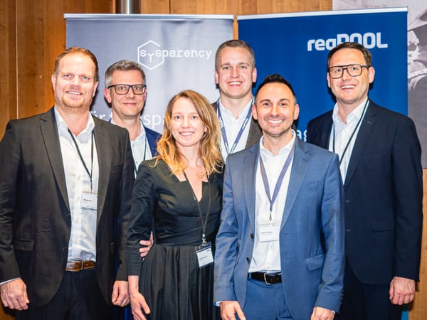 Gruppenfoto von sieben Personen vor Bannern von Sysparency und ReqPOOL