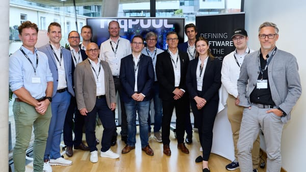Gemeinsames Gruppenfoto der Gäste vor dem ReqPOOL-Bildschirm und Banner