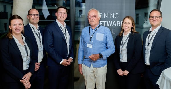 Sechs Personen in Business-Kleidung posieren vor einem ReqPOOL-Banner