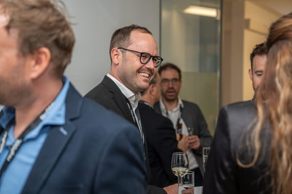 Lächelnder Gast mit Brille im Gespräch