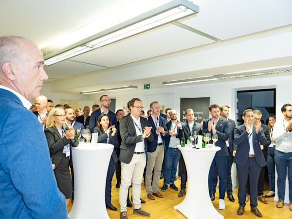 Gäste applaudieren an Stehtischen, im Hintergrund ein ReqPOOL-Banner