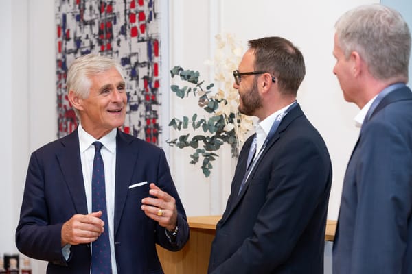 Drei Gäste im Gespräch vor einer gemusterten Wand